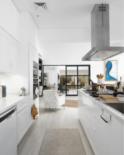 Step inside a stunning Arabian Ranches modern white kitchen designed by Aqsa Owais, featuring a spacious island, open-plan living, and vibrant pops of color throughout a light, airy interior that blends function with fresh, contemporary style.